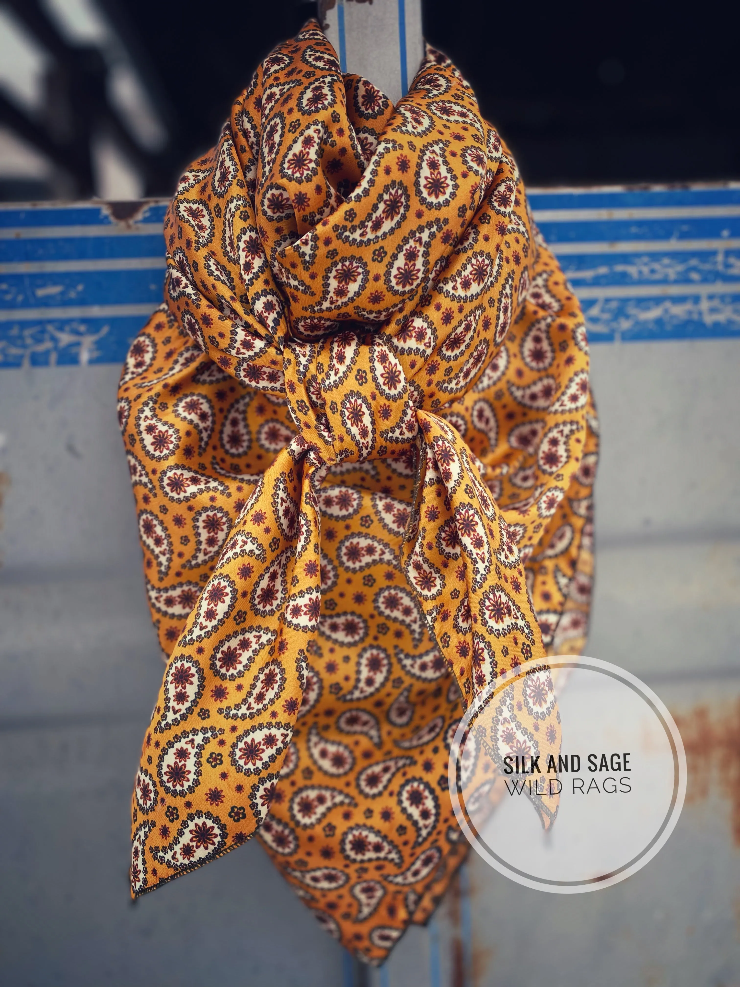 Bright mustard with rust, dark green and white  paisley floral print on a silky charmeuse fabric.