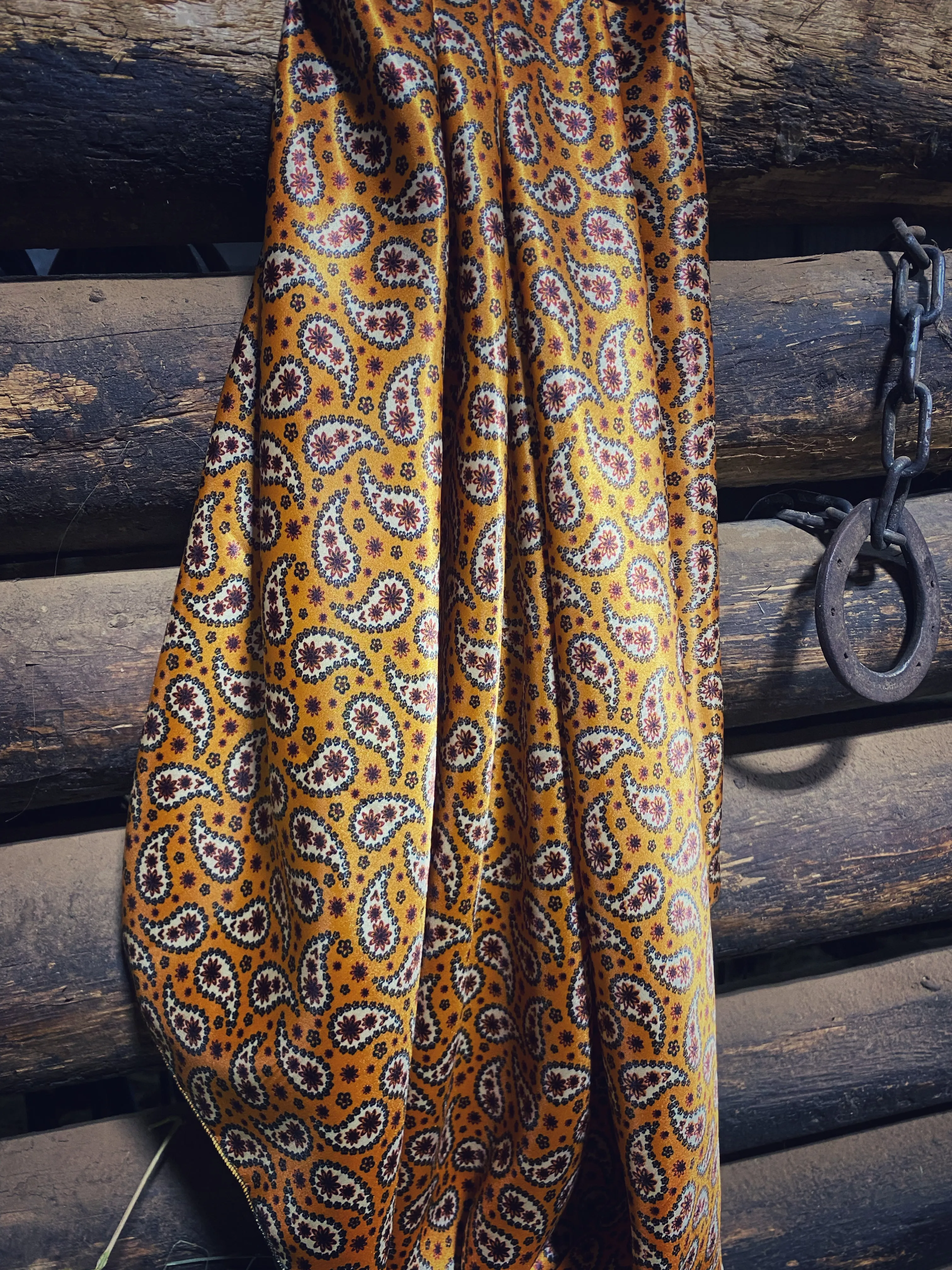 Bright mustard with rust, dark green and white  paisley floral print on a silky charmeuse fabric.