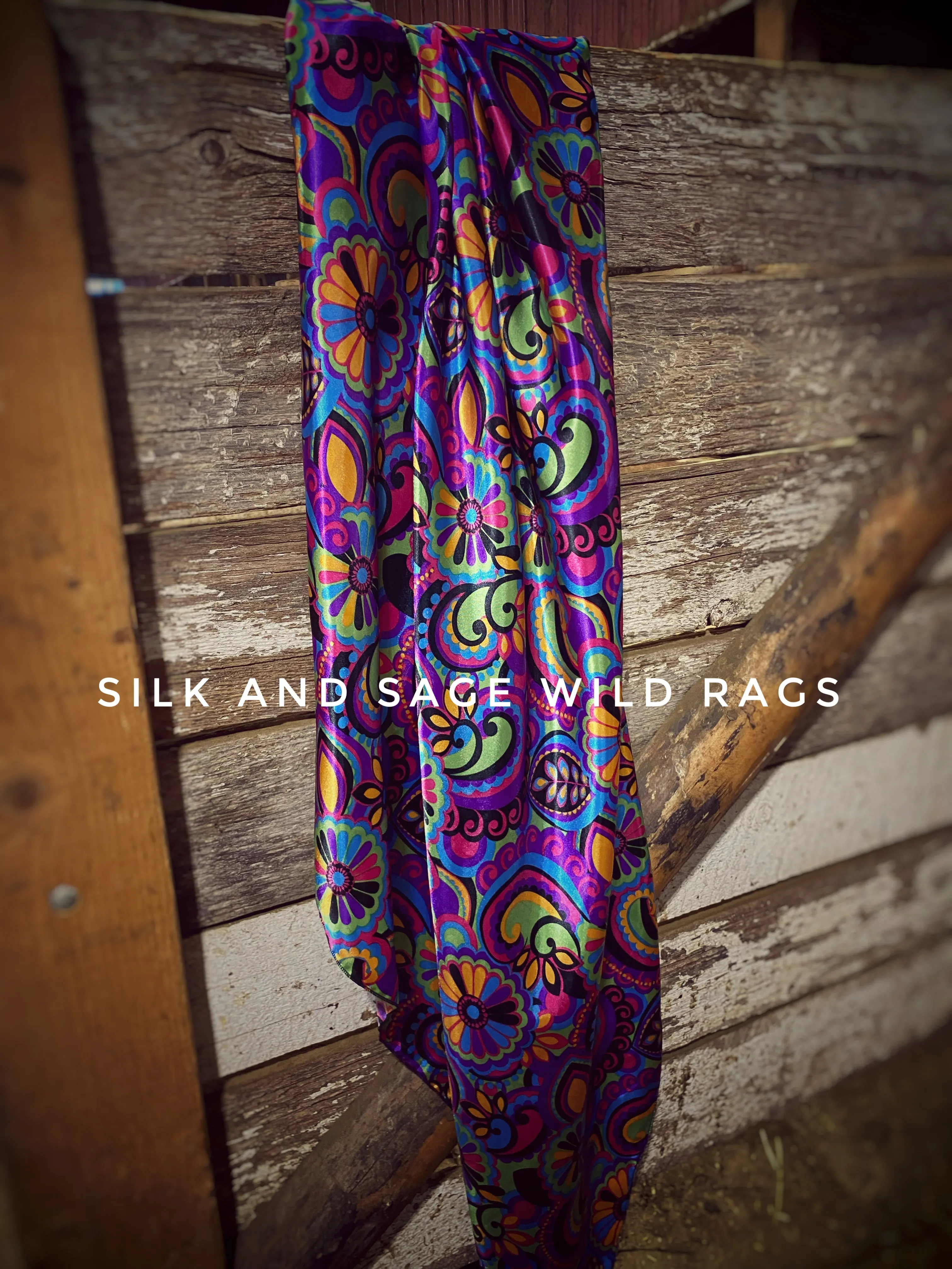 Colorful  purple, pink, green, blue, yellow and black paisley and floral print on a silky charmeuse fabric.